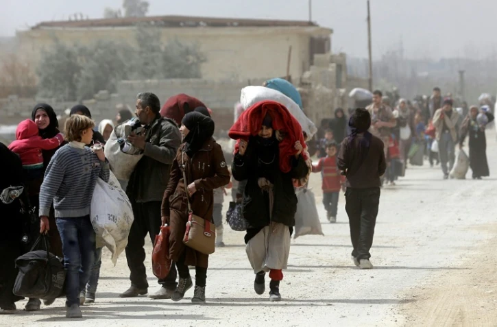 Des Syriens arrivent au point de passage de Adra, tenu par les forces du régime à la périphérie de Damas, fuyant l'enclave rebelle dans la Ghouta orientale