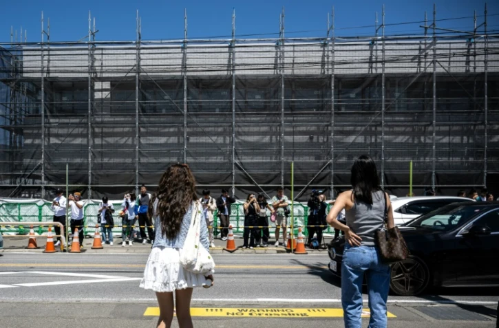 Des touristes dans une rue de la ville de Fujikawaguchiko avant l'installation d'un vaste filet pour cacher la vue du Mont Fuji, le 3 mai 2024 au Japon