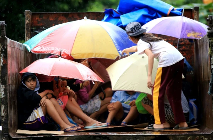 Des habitants de Barangay Matnog, dans la province d'Albay, aux Philippines, évacuent leurs maisons devant l'avancée du typhon Nock-Ten, le 25 décembre 2016
