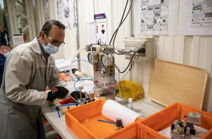 Un employé du groupe automobile PSA assemble les pièces d'un respirateur médical, le 15 avril 2020 à l'usine de Poissy, au nord-ouest de Paris