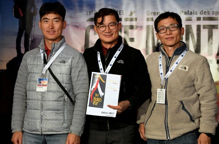 L'alpiniste sud-coréen Kim Chang-ho (centre), et ses camarades Ho Seok-mun (g) et Park Joung-yong (d) lors d'une remise de médaille à Grenoble, le 8 novembre 2017