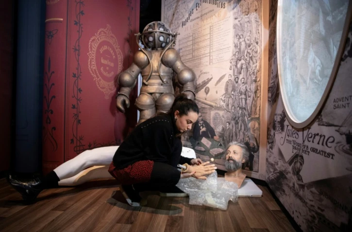 Des employés du musée Grévin à Paris préparent la statue de cire de Jules Verne, le 5 janvier 2019