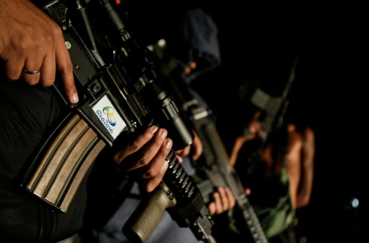 Des jeunes habitants d'une favela se présentant comme des trafiquants de drogue, posent avec des fusils mitrailleurs, le 20 août 2016 à Rio