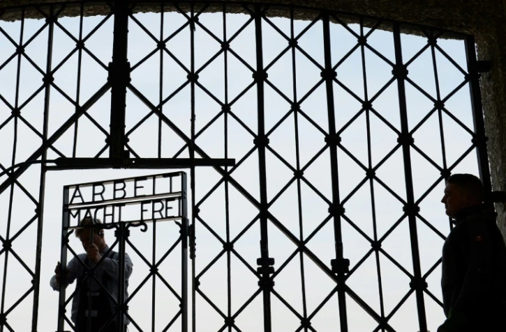 Des ouvriers fixent la réplique du portail portant l'inscription "Arbeit macht frei" de l'ancien camp de concentration de Dachau, dans le sud de l'Allemagne, le 29 avril 2015