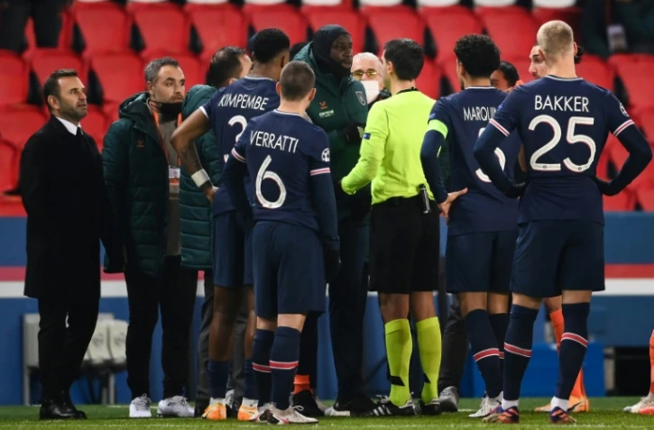 L'attaquant d'Istanbul Basaksehir Demba Ba (au centre) en discussion avec l'arbitre du match PSG-Basaksehir à Paris après une interruption en raison de propos supposés racistes du 4e arbitre, le 8 décembre 2020