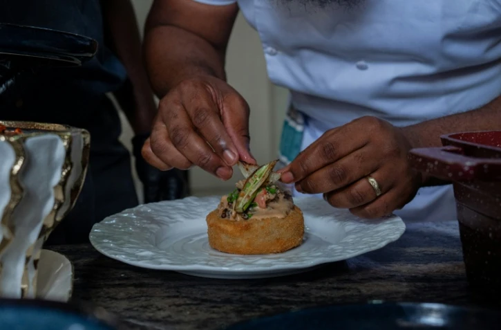 Le chef congolais Archi Dimosi dresse l'une de ses spécialités, le 17 mai 2026 à Kinshasa, en RDC
