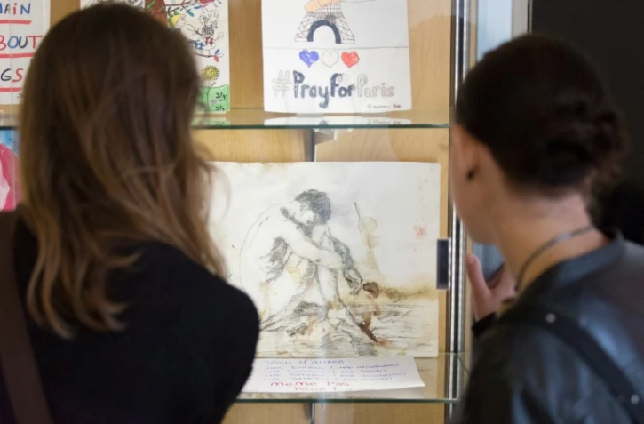 Des visiteurs regardent des dessins et des cartes réalisés après les attentats de Paris collectés par les Archives de Paris, à Paris le 17 septembre 2016