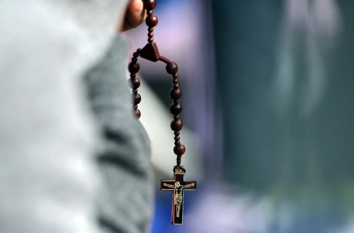 Un homme prie le 27 septembre 2015 à Philadelphie, en Pennsylvanie, en attendant l'arrivée du pape venant célébrer une messe en plein air 