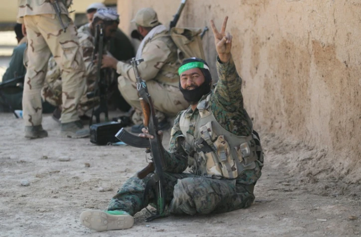 Des combattants chiites des Unités de la mobilisation populaire, font le signe de la victoire dans un village du sud de Mossoul à Ayn Nasir, le 29 octobre 2016