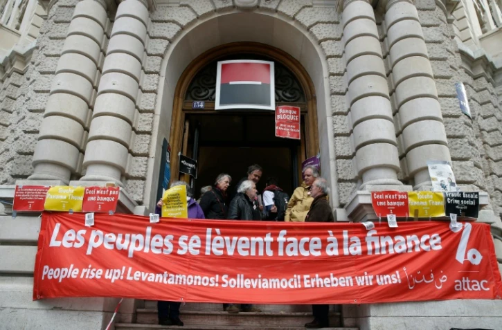 Des membres de l'association Attac bloquent l'entrée d'une agence de la Société Générale à Paris le 7 avril 2016