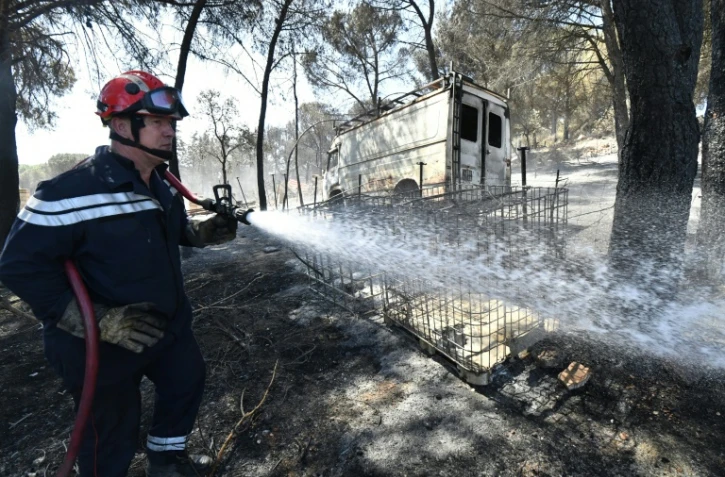 Un pompier déverse de l'eau le 3 août 2019 dans un jardin brûlé de Générac (Gard) où un feu a détruit près de 800 hectares