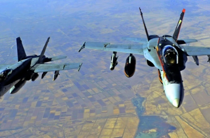 (ARCHIVES) Une photo fournie par la marine américaine montre deux F-18E Super Hornets américains soutenant des opérations contre les jihadistes au-dessus de l?Irak, le 4 octobre 2014