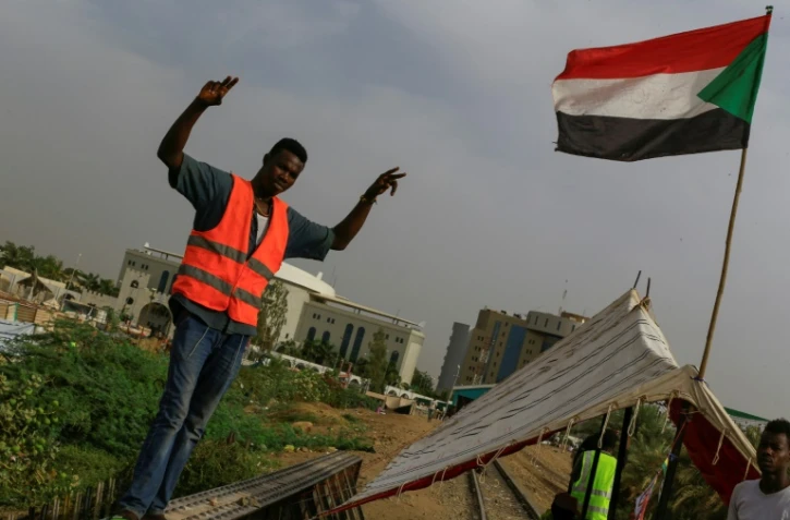 Un manifestant occupe une voie ferrée à Khartoum pour réclamer le retour du pouvoir aux civils, le 12 mai 2019