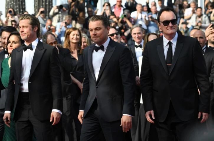 (De G à D) Les acteurs américains Brad Pitt et Leonardo DiCaprio montent les marches à Cannes le 21 mai 2019 au côté du réalisateur américain Quentin Tarantino