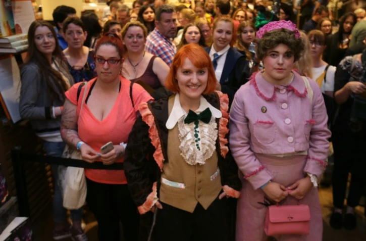 Des fans de Harry Potter posent pour des photographes lors de la mise en vente du nouvel opus "Harry Potter et l'enfant maudit", dans une librairie de Londres, le 31 juillet 2016