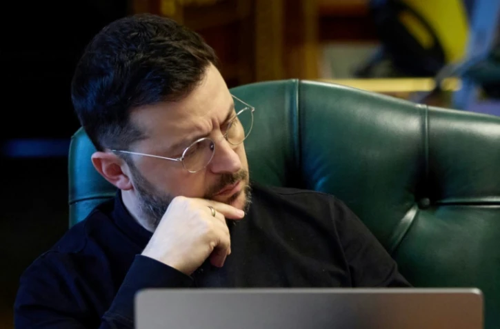 Le président ukrainien Volodymyr Zelensky écoute ses interlocuteurs - le président français, le Premier ministre anglais et le chancelier allemand - lors d'un échange téléphonique, dans son bureau à Kiev, le 21 novembre 2025 