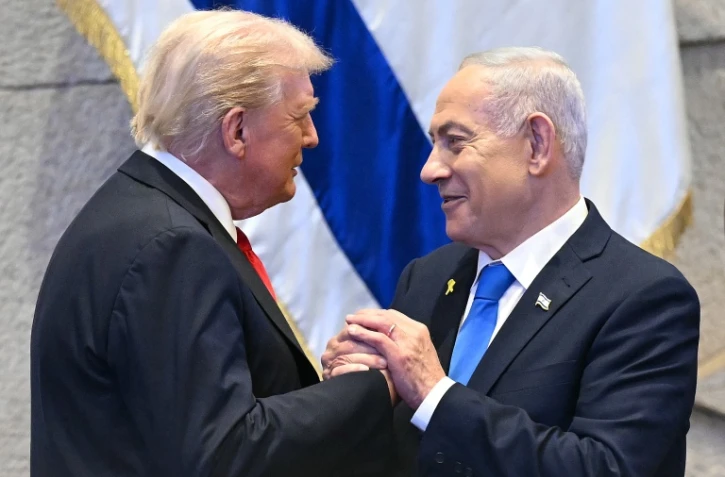 Le président américain Donald Trump (g.) échange avec le Premier ministre israélien Benjamin Netanyahu, le 13 octobre 2025 à Jérusalem