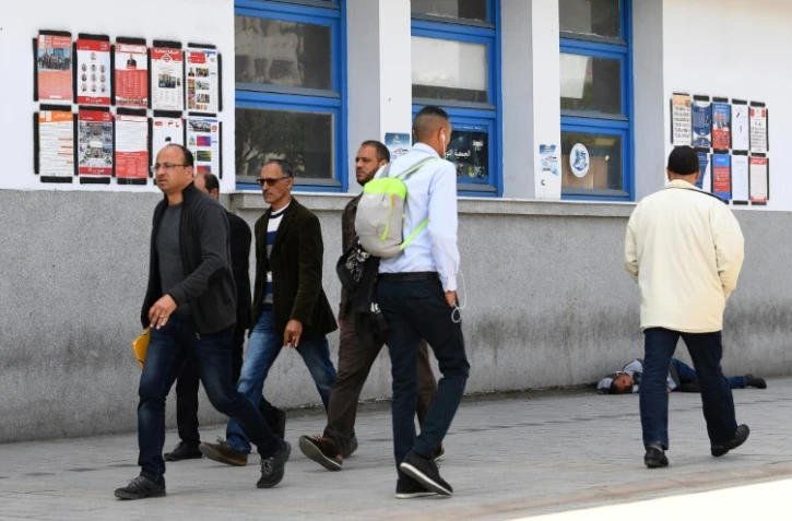 Des Tunisiens passent devant des affiches électorales pour les municipales, le 4 mai 2018 à Tunis