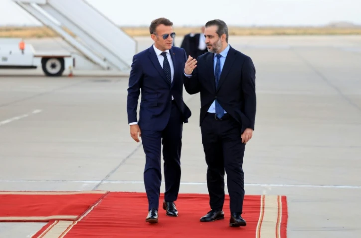 Le président français Emmanuel Macron (g) est accueilli par le ministre syrien des Affaires étrangères Assaad al-Chaibani (d) à son arrivée à l'aéroport international de Damas, pour une visite d'État, le 6 juillet 2026 en Syrie