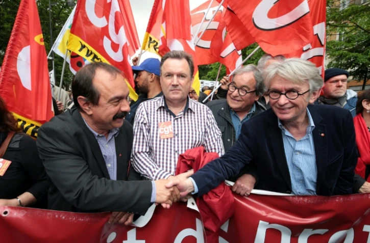 Les secrétaires généraux de la CGT, Philippe Martinez (G) et FO, Jean-Claude Mailly (D) se serrent la main en tête de cortège contre la loi Travail, le 12 mai 2016 à Paris