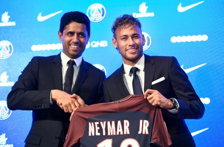 La star brésilienne Neymar (d) pose avec le maillot de son nouveau club, le PSG, à côté de Nasser Al-Khelaifi, président du club parisien, le 4 août 2017 à Paris   