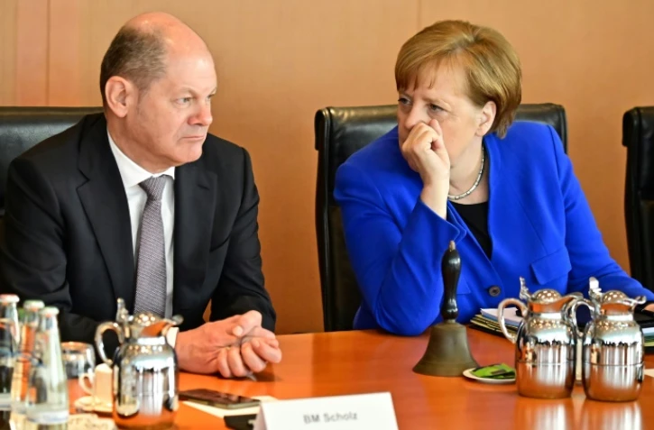 Le ministre allemand des Finances Olaf Scholz (G) au côté de la chancelière Angela Merkel (D) à Berlin le 10 avril 2019