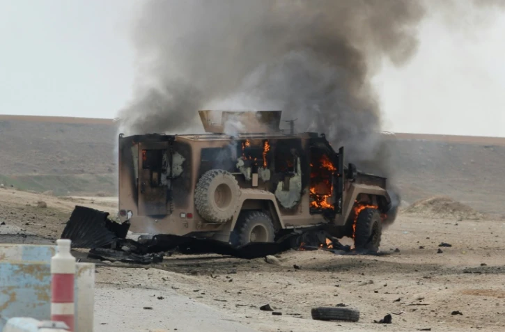 Un véhicule militaire est en feu sur le site d'une attaque kamikaze revendiquée par le groupe jihadiste Etat islamique (EI) contre un convoi des forces américaines et de leurs alliés locaux en Syrie, dans la province de Hassaké (nord-est), le 21 janvier 2019
