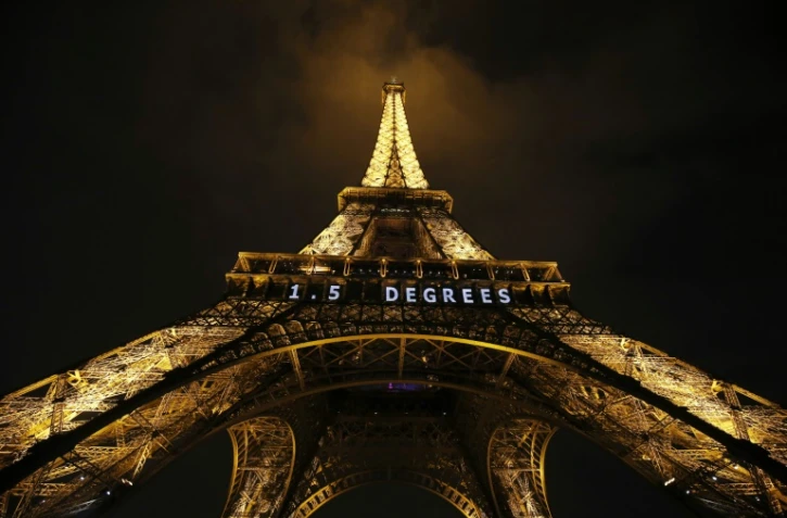 "1,5 degré" est inscrit en néon blanc sur la Tour Eiffel, le 10 décembre 2015 la veille de la clôture de la COP21