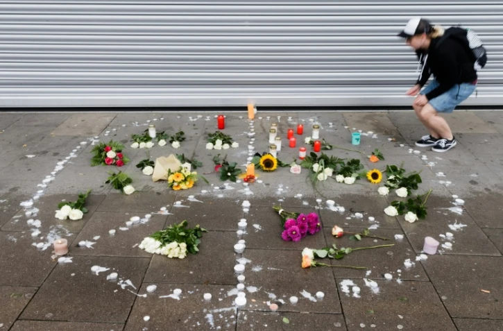 Une femme dispose une bougie à proximité du lieu de l'agression mortelle d'un homme à Hambourg, le 29 juillet 2017