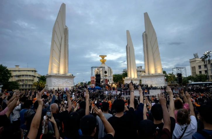 Des partisans de Move Forward font le salut à trois doigts devant le Monument de la Démocratie, lors d'un rassemblement après le rejet définitif par le Parlement de la candidature de Pita Limjaroenrat au poste de Premier ministre, le 19 juillet 2023 à Bangkok, en Thaïlande
