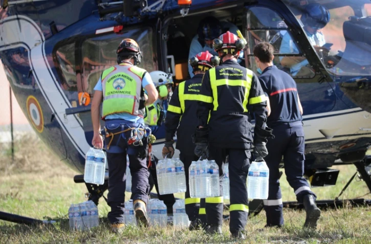 Des packs d'eau sont transportés vers un hélicoptère le 5 octobre 2020 à Breil-sur-Roya (Alpes-Maritimes) 