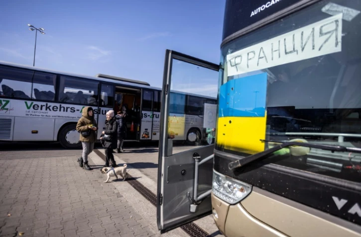 Un drapeau ukrainien et un panneau "France" sur un bus pour les réfugiés d'Ukraine, à Przemysl, dans le sud-est de la Pologne, le 20 mars 2022