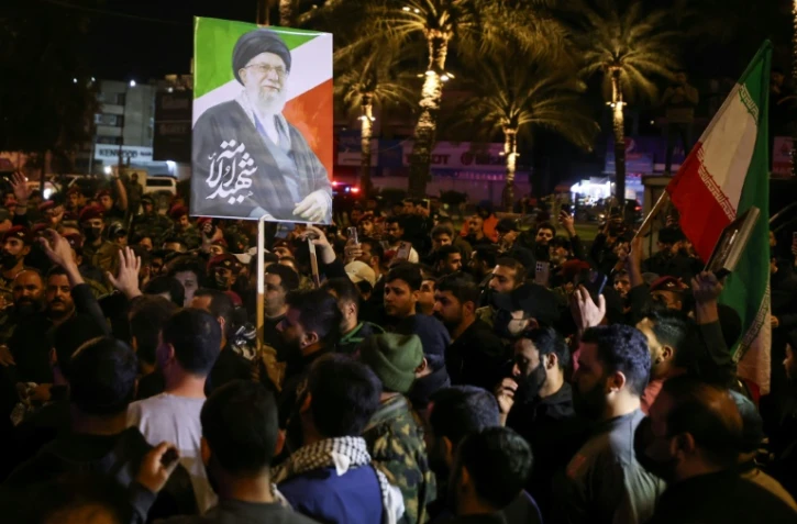 Un portrait du guide suprême iranien Ali Khamenei, tué au premier jour de la guerre, est brandi au cours des funérailles de membres d'une milice irakienne pro-Téhéran à Bagdad, le 17 mars 2026