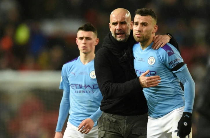 L'entraîneur de Manchester City Pep Guardiola conseille Nicolas Otamendi lors d'un match de Premier League face à Manchester United, à Old Trafford, le 8 mars 2020