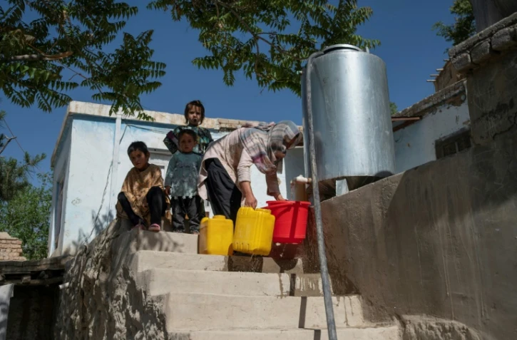 Une habitante récupère de l'eau potable à partir d'une citerne à Kaboul, le 27 avril 2025 en Afghanistan