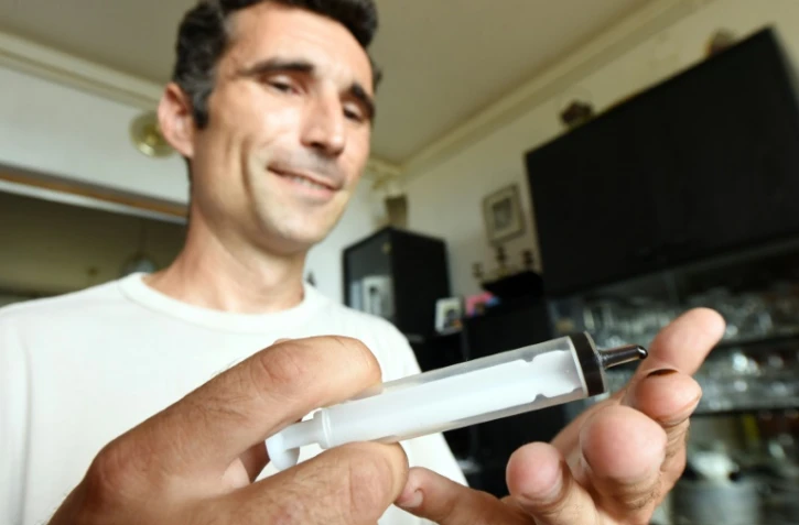 Huanito Luksetic, atteint de sclérose en plaques, tient une seringue d'huile de cannabis dans ses mains, le 13 juillet 2016 à Rijeka en Croatie