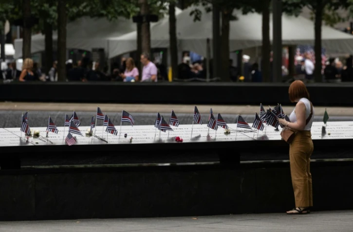 Une personne place un drapeau américain sur le mémorial pour les victimes du 11-Septembre à New York, le 11 septembre 2022
