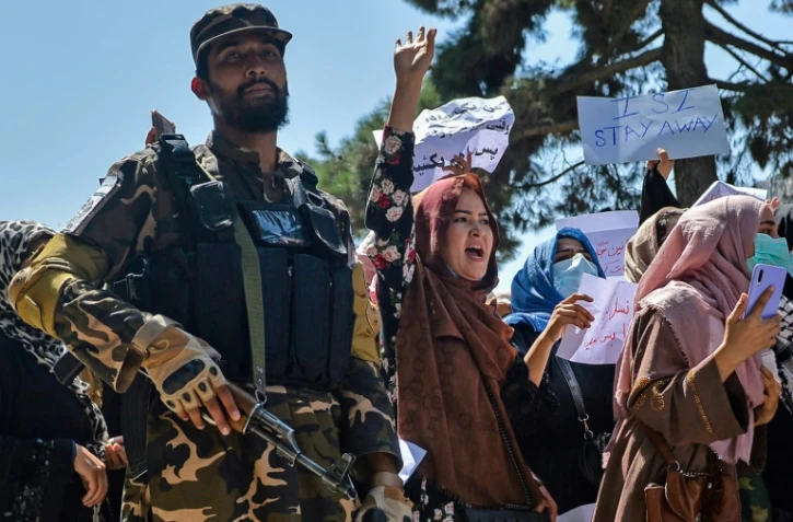 Des Afghanes manifestent contre l'ingérence du Pakistan, sous l'oeil d'un combattant taliban, à Kaboul le 7 septembre 2021