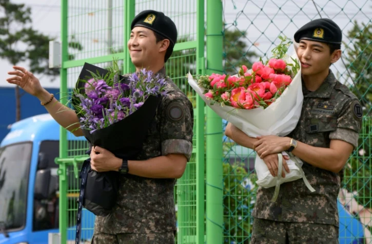 Les membres du boys band K-pop BTS, RM (L) et V à Chuncheon, en Corée du Sud, le 10 juin 2025, après leur libération du service militaire