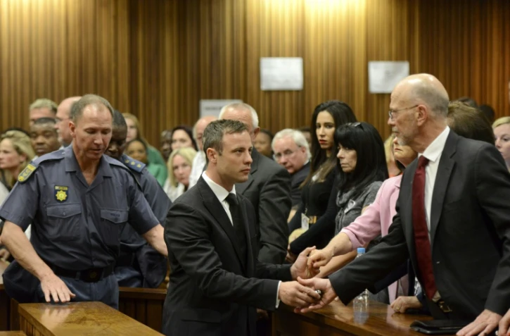 Oscar Pistorius serre la main de son oncle Arnold Pistorius avant d'être emmené en prison à l'issue de son procès le 21 octobre 2014 à Pretoria