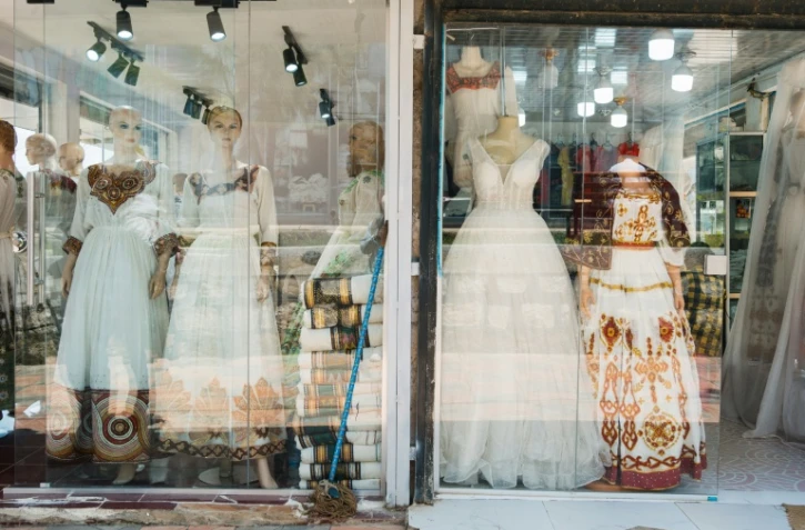 Des netela et des habesha kemis (vêtements traditionnels éthiopiens) dans la vitrine d'un magasin du quartier Shiromeda à Addis Abeba, le 7 octobre 2025 en Éthiopie