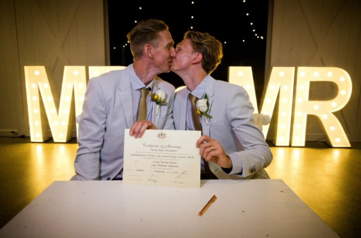 Australian athletes Craig Burns (L) and Luke Sullivan (R) kiss after their marriage ceremony at Summergrove Estate, New South Wales on January 9, 2018