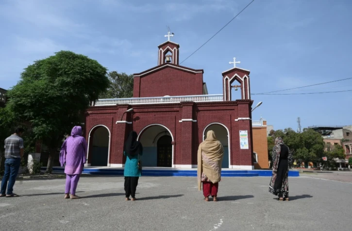 Des fidèles chrétiens prient à l'extérieur, devant une église à Lahore, le 10 avril 2020 au Pakistan