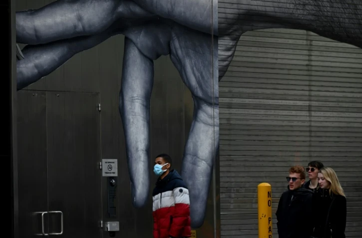 Un homme marche devant une fresque murale à New York, le 14 mars 2020