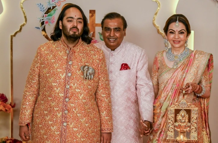 Le magnat Mukesh Ambani (c) et son épouse Nita Ambani (d) arrivent à la cérémonie de mariage de leur fils Anant (g), le 12 juillet 2024 à Bombay, en Inde