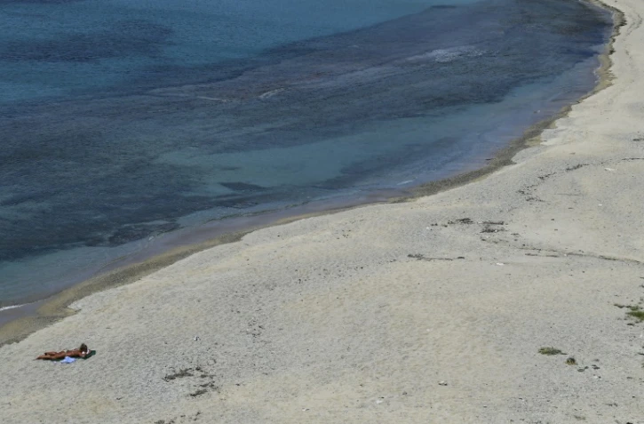 Une femme bronze sur une plage déserte de l'île de Mykonos, en Grèce, le 12 mai 2020