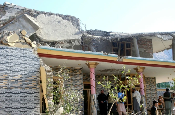 Des Afghans se rassemblent devant une maison endommagée par une frappe pakistanaise à Asadabad dans l'est de l'Afghanistan le 25 novembre 2025