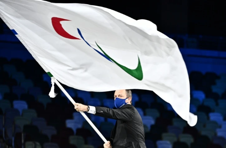 Andrew Parsons, président du Comité international paralympique (CIP), tient le drapeau paralympique, le 5 septembre 2021 à Tokyo