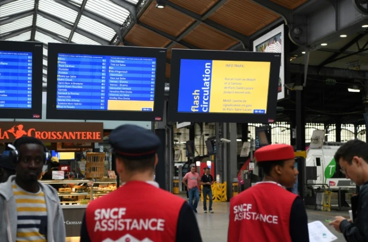 Des employés de la SNCF assistent les voyageurs le 13 juin 2018 à la gare de Saint-Lazare où le trafic est totalement interrompu