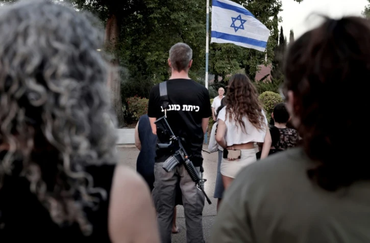 Les habitants du kibboutz israélien de Sha'ar Hagolan, près de la Jordanie, assistent à une cérémonie du drapeau pour rendre hommage, le 12 octobre 2023, aux Israéliens tués lors de l'attaque du Hamas le 7 octobre 2023